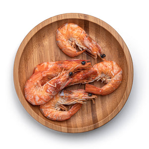 6 shrimps on a wooden round plate